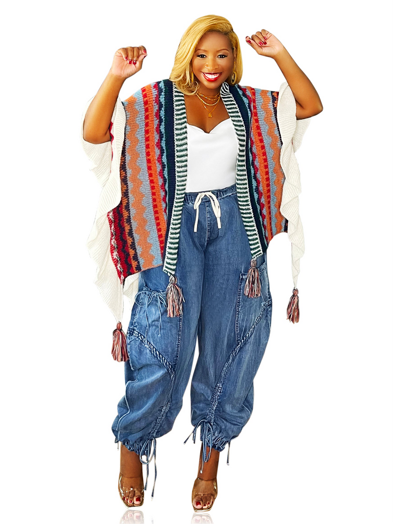Woman wearing a multicolor fashion shawl with a loose fit and tassel details. Draped over the shoulders for a cozy, stylish look—perfect paired with jeans or a sundress. One size fits all.
