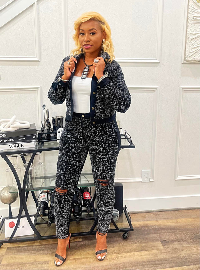 Woman wearing black distressed jeans with sparkling bling accents. Fashion-forward with a comfortable stretch fit. Model is 5'5" and 160 pounds, wearing a size medium. Pairs with matching 'Bling is Better' jacket.