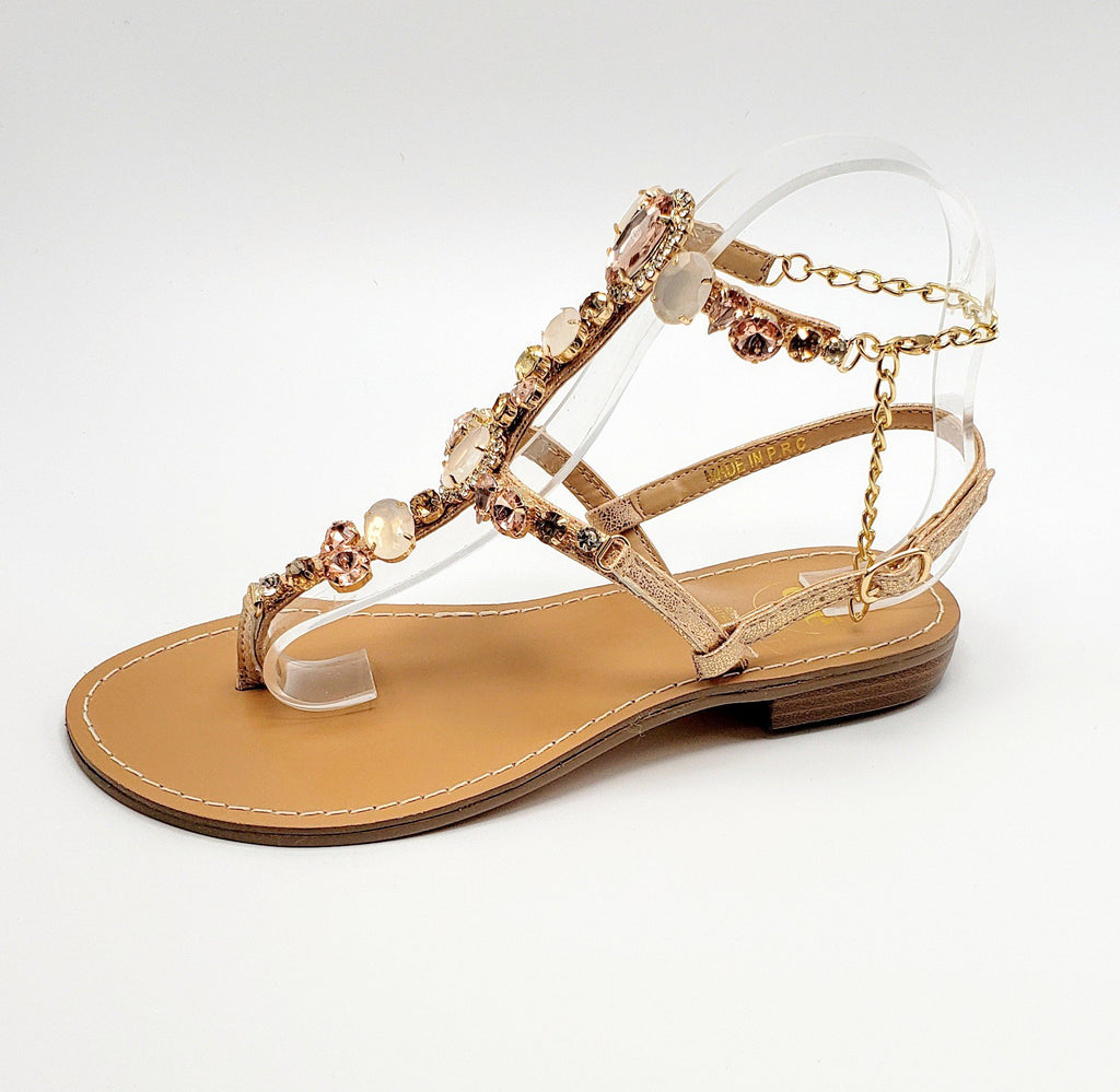 Champagne colored leather trim eloquently adorned with bedazzled jewels that accent the outer trim of the sandal.